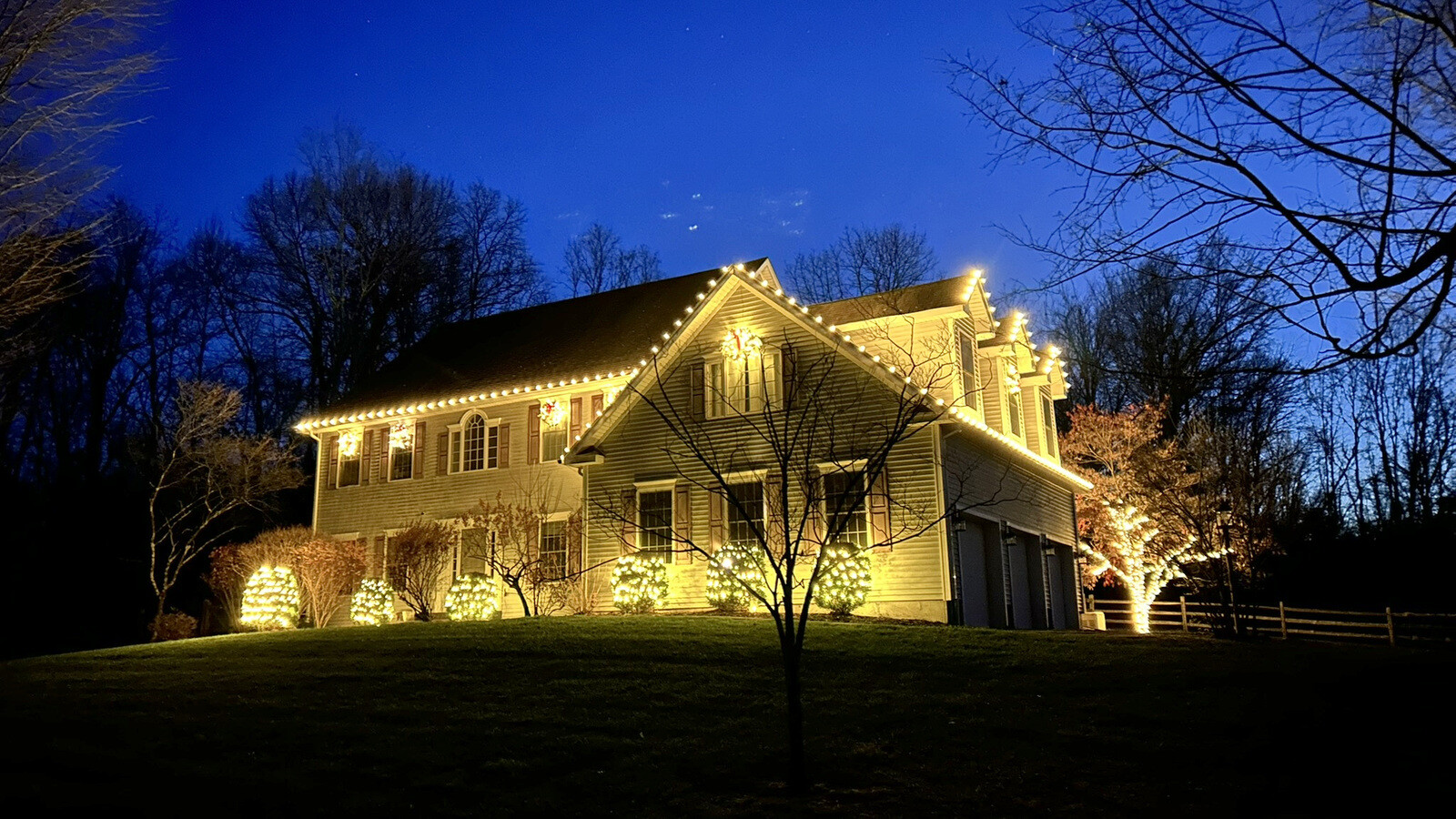 A home and street beautifully lit for Christmas at night